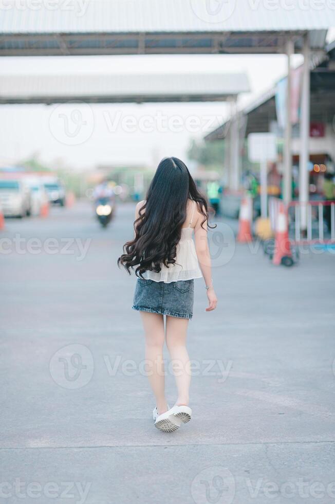bellissimo asiatico donna pose nel moda stile, bianca camicia, jeans gonna. foto