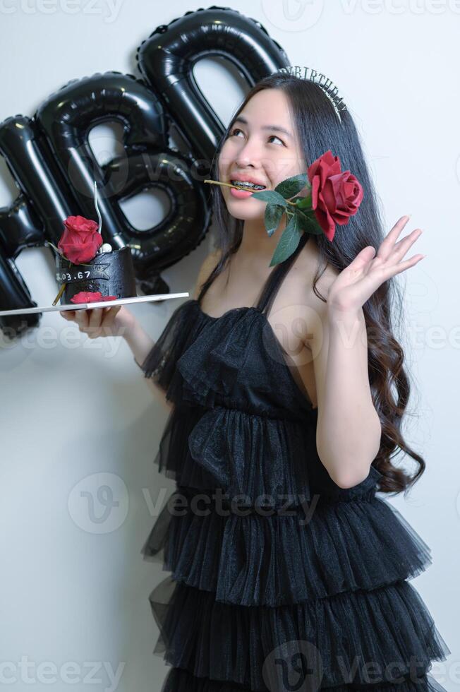 bellissimo donna indossare un' nero vestito e cioccolato torta nel il concetto di compleanno foto