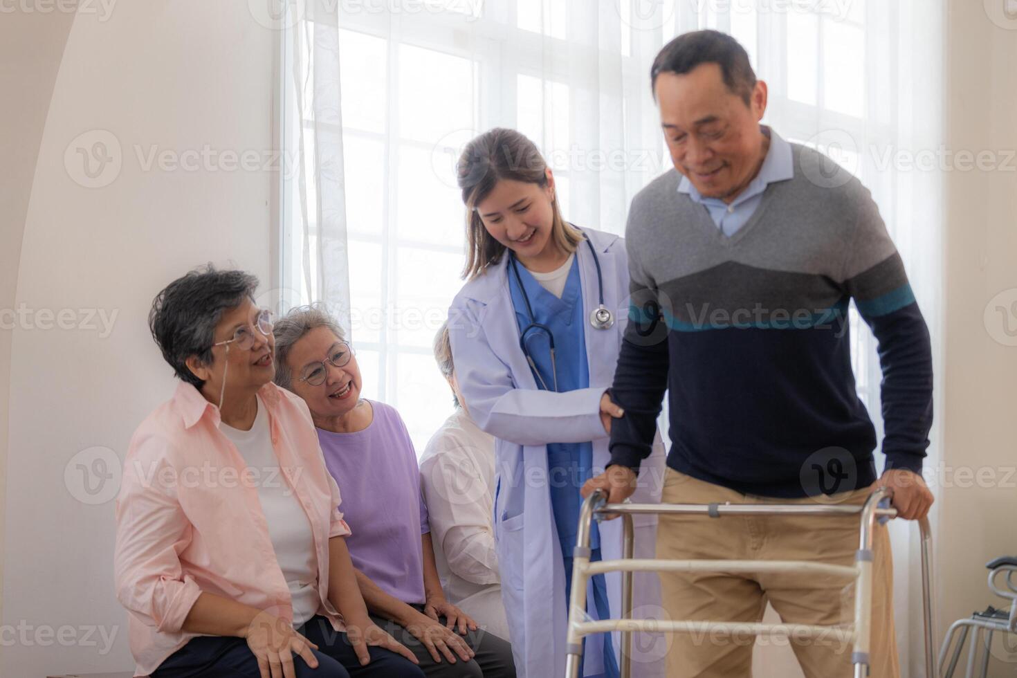 asiatico giovane infermiera supporto anziano più vecchio uomo camminare con camminatore. bellissimo infermiera Aiuto e prendere cura. anziano maturo Nonno paziente fare fisico terapia con un' gruppo di anziano amici nel Ospedale. foto
