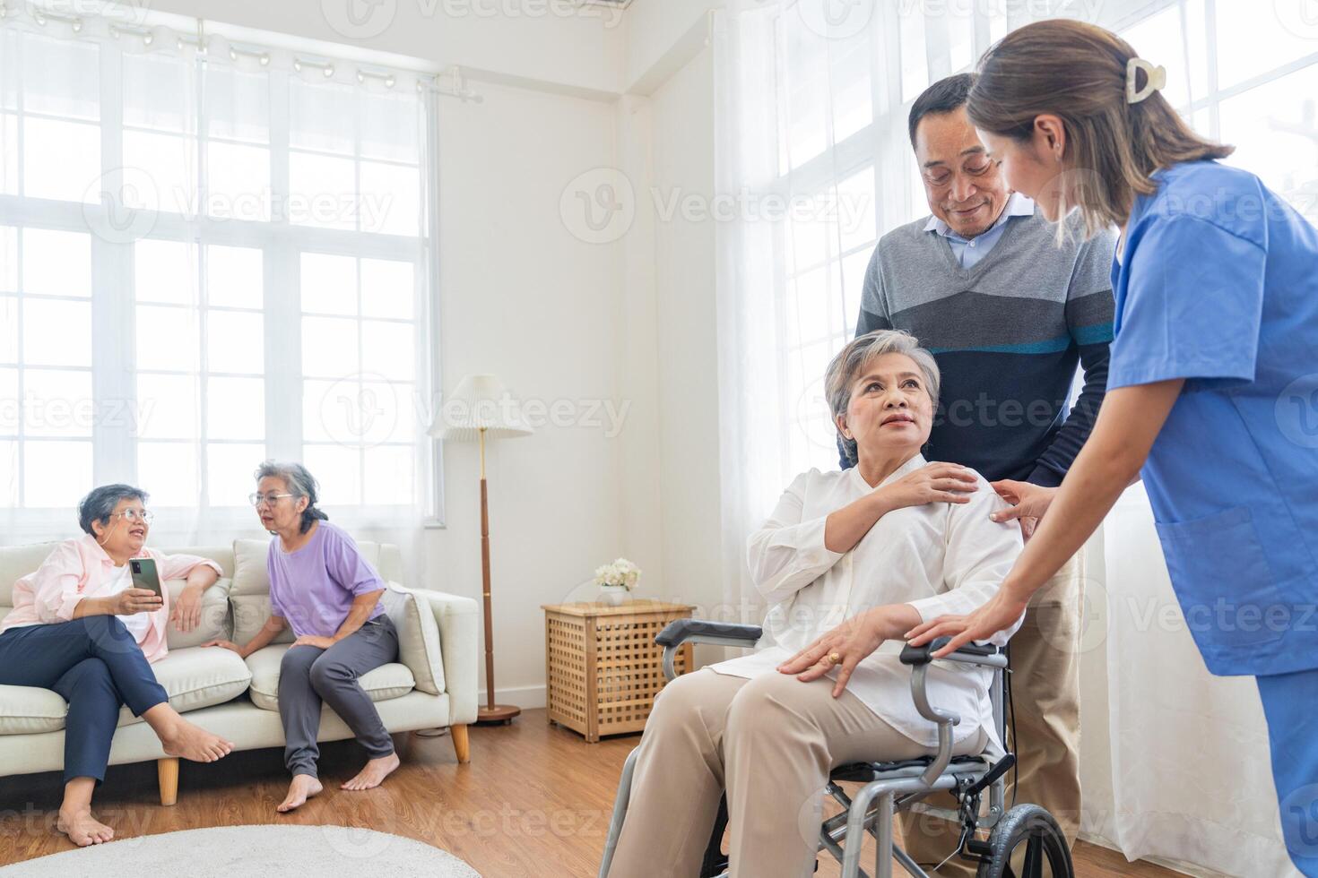 asiatico giovane infermiera supporto coppia anziano più vecchio uomo e donna nel un' sedia a rotelle. anziano maturo e un' gruppo di anziano amici vivente nel il Ospedale. socializzazione di pensionato le persone. foto