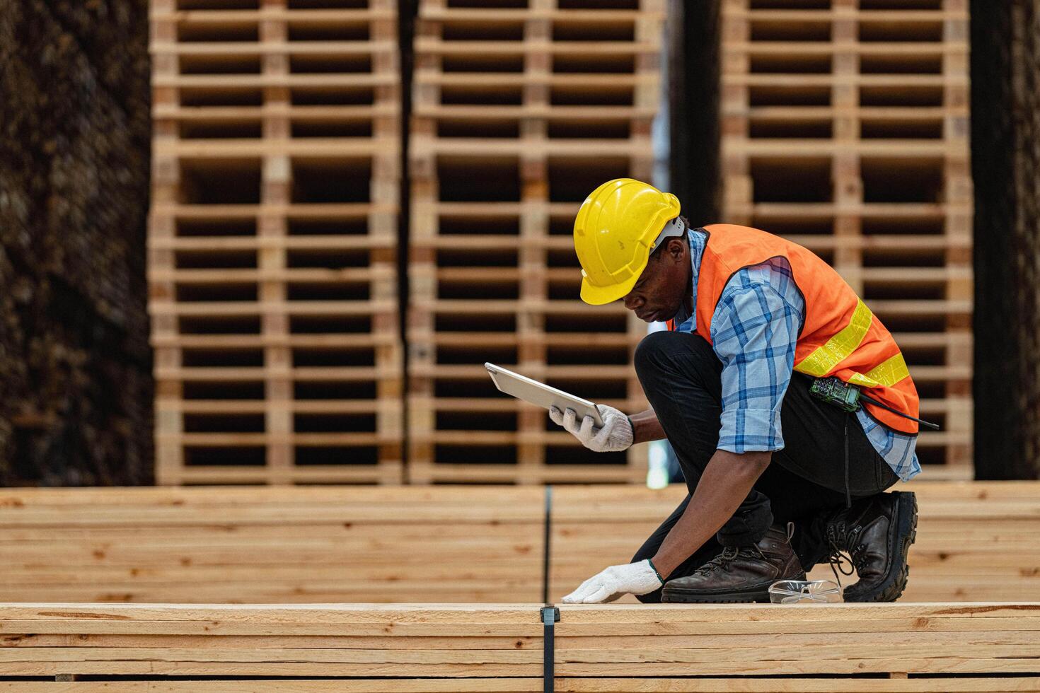 africano lavoratori uomo ingegneria a piedi e ispezionando con Lavorando suite vestito e mano guanto nel legname legna magazzino. concetto di inteligente industria lavoratore operativo. legna fabbriche produrre legna palato. foto