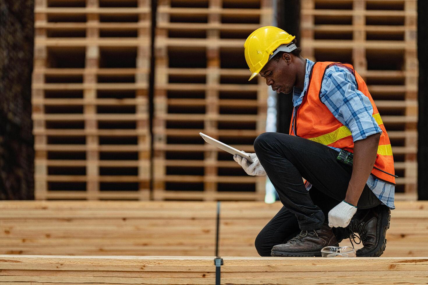 africano lavoratori uomo ingegneria a piedi e ispezionando con Lavorando suite vestito e mano guanto nel legname legna magazzino. concetto di inteligente industria lavoratore operativo. legna fabbriche produrre legna palato. foto