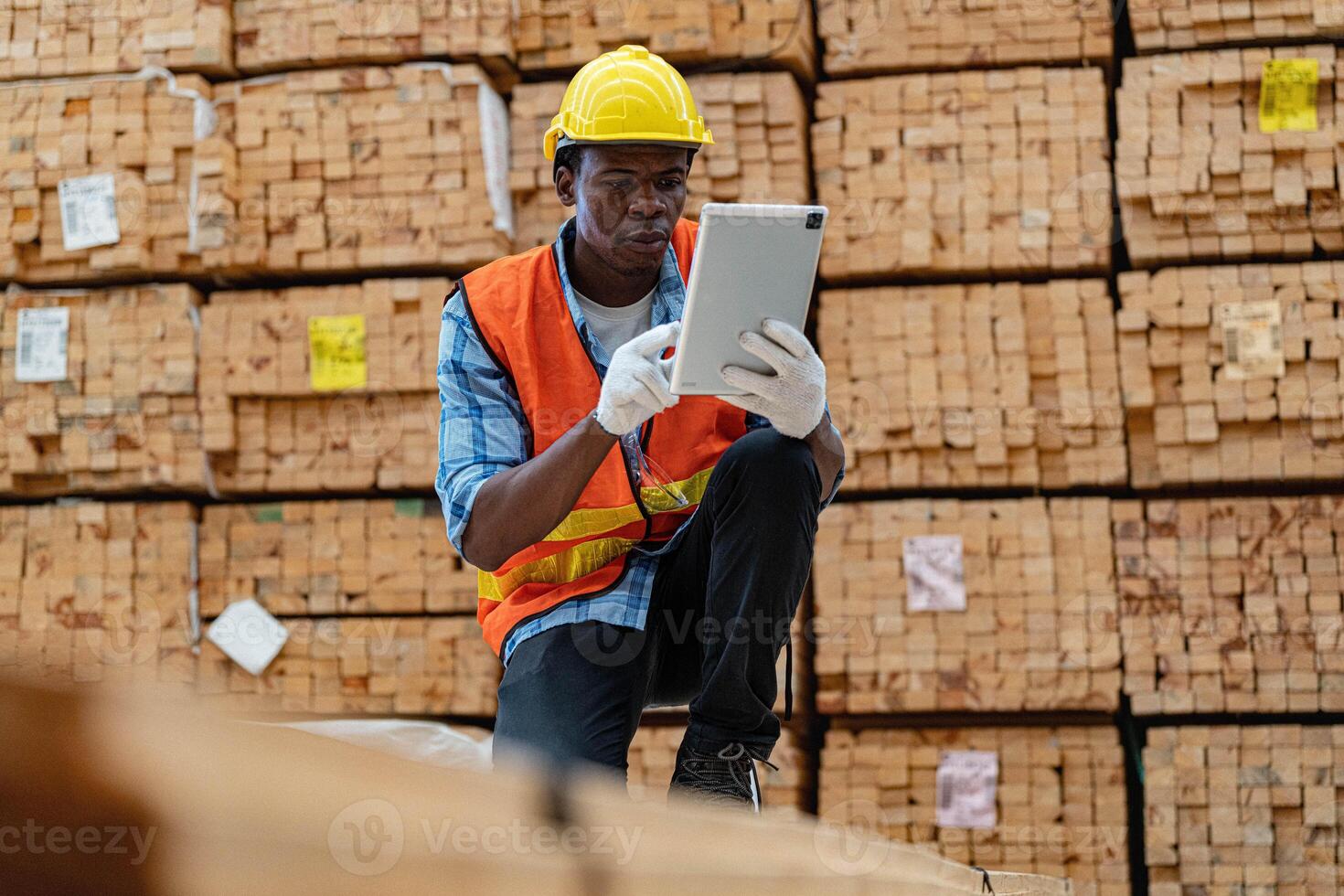 africano lavoratori uomo ingegneria a piedi e ispezionando con Lavorando suite vestito e mano guanto nel legname legna magazzino. concetto di inteligente industria lavoratore operativo. legna fabbriche produrre legna palato. foto