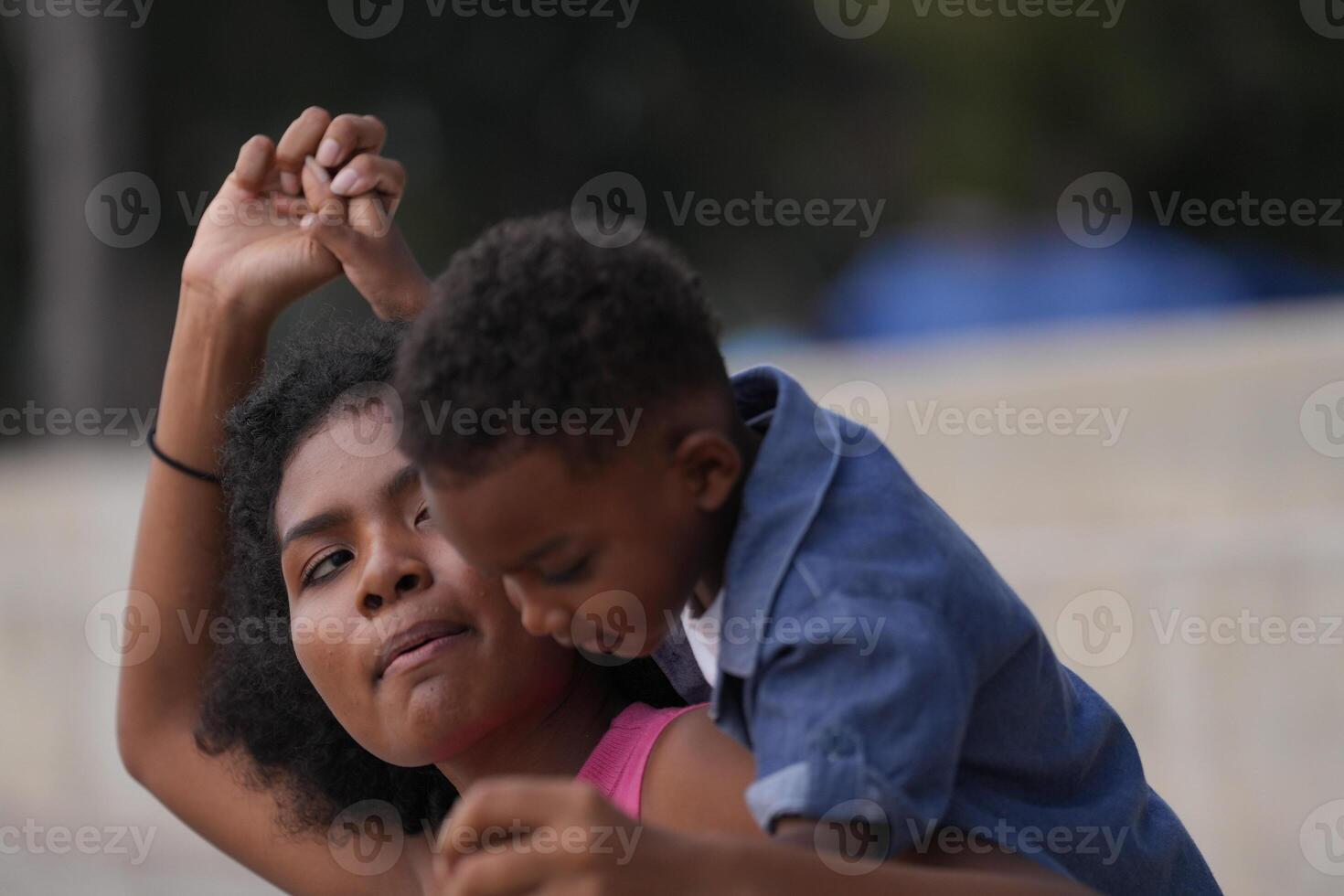 misto gara africano e asiatico madre e ragazzo è giocando a il all'aperto la zona. sorridente contento famiglia avere divertimento in esecuzione su il spiaggia. ritratto di mamma e ragazzo stile di vita con un' unico acconciatura. foto