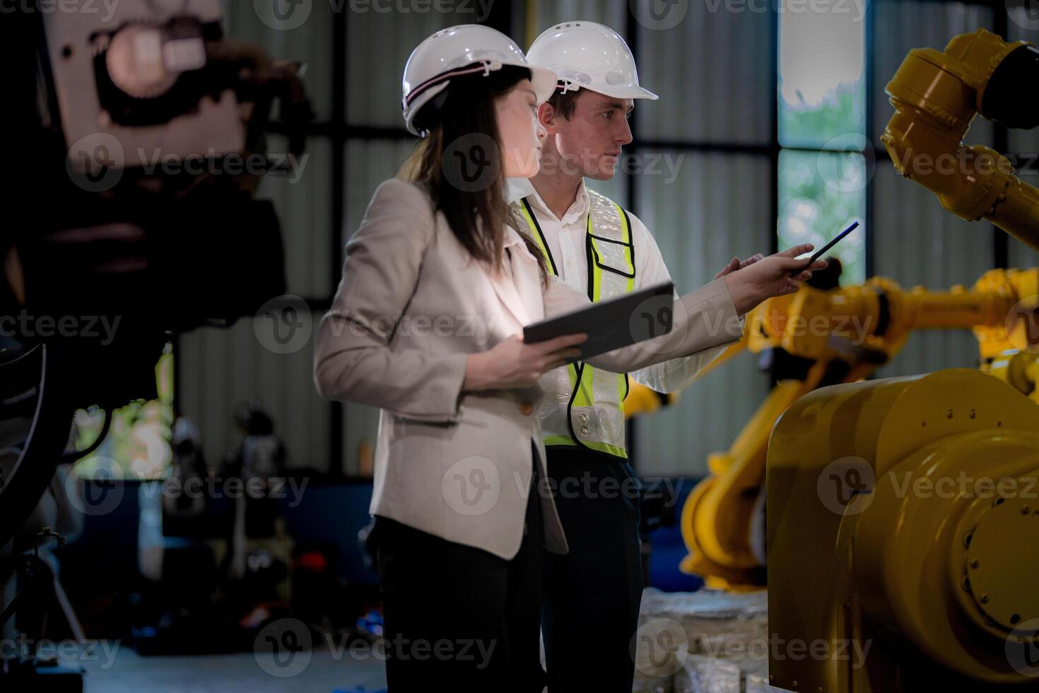 attività commerciale donna e uomo incontro e controllo nuovo macchina robot. ingegnere a piedi a magazzino industria macchina. attività commerciale trattativa concetti e tecnologia. donna è utilizzando inteligente tavoletta per presente uomo. foto