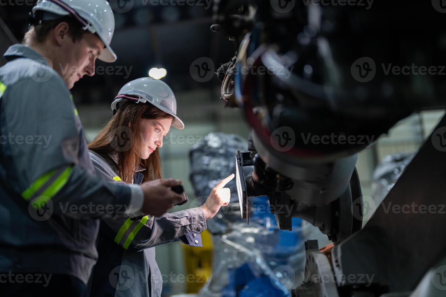 ingegneri dai un'occhiata controllo pesante macchina robot braccio. diverso squadra di industriale robotica ingegneri si riunirono in giro macchina. professionale macchinari operatori riparazione elettrico robot su luminosa digitale pannello. foto