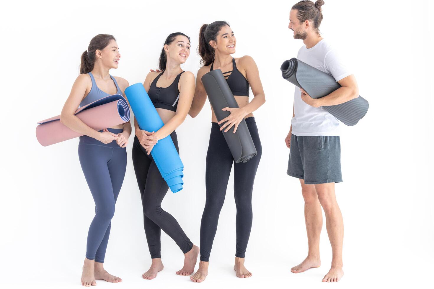 gruppo di contento sportivo donne e tipo indossare corpo elegante abbigliamento sportivo Tenere personale tappeti Appoggiato su un' bianca sfondo. in attesa per yoga classe o corpo peso classe. salutare stile di vita e benessere foto