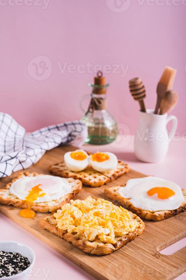 strapazzate uovo, in camicia uovo, fritte uovo, bollito uovo su crostini su un' tavola verticale Visualizza foto