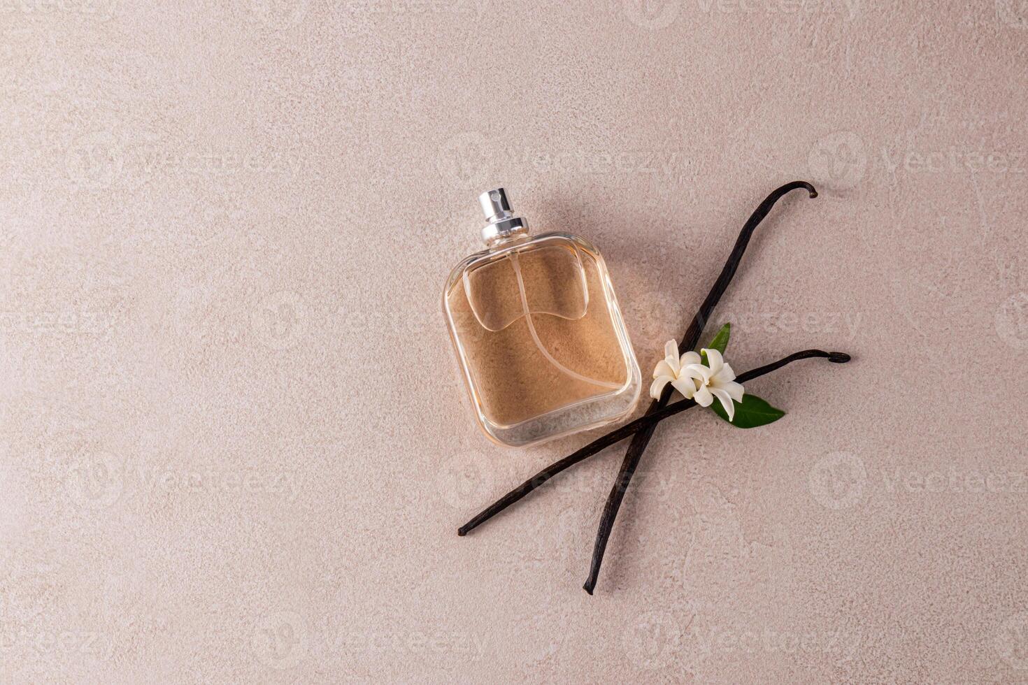 bicchiere bottiglia di profumo o cosmetico spray con naturale vaniglia profumo su beige pietra sfondo con vaniglia bastoni. superiore Visualizza. un' copia spazio. foto