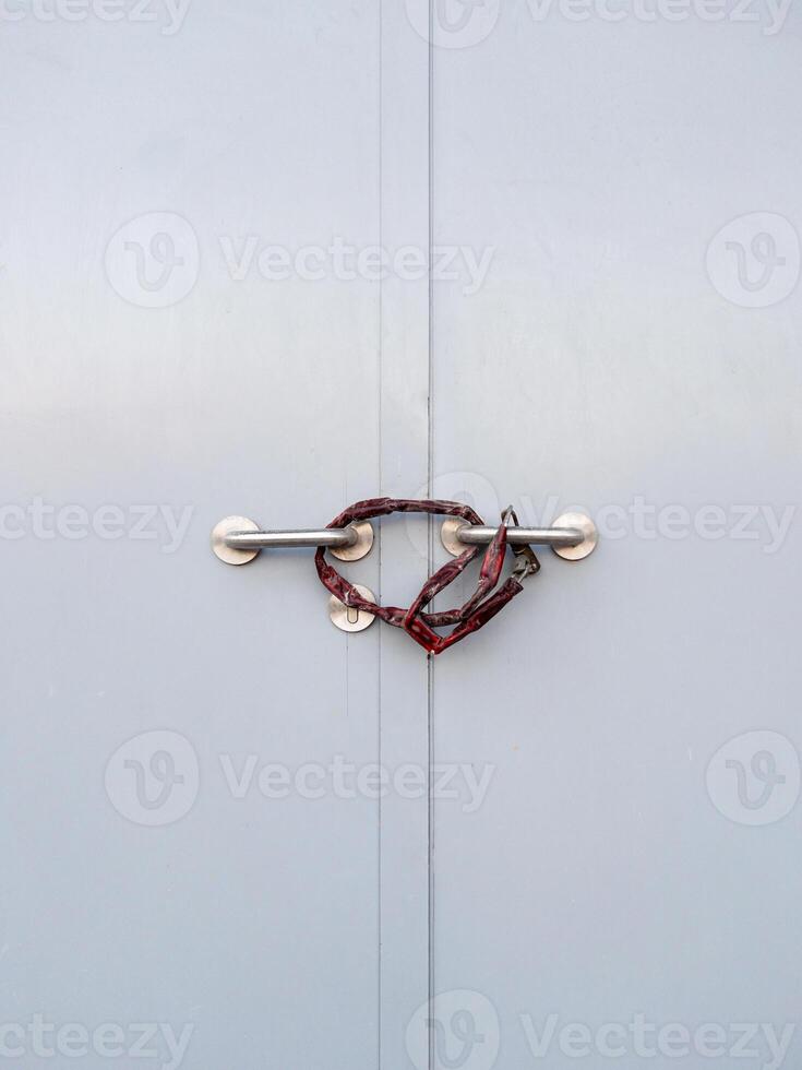 avvicinamento di il metallo porta maniglia bloccato con catena e pagaia. foto