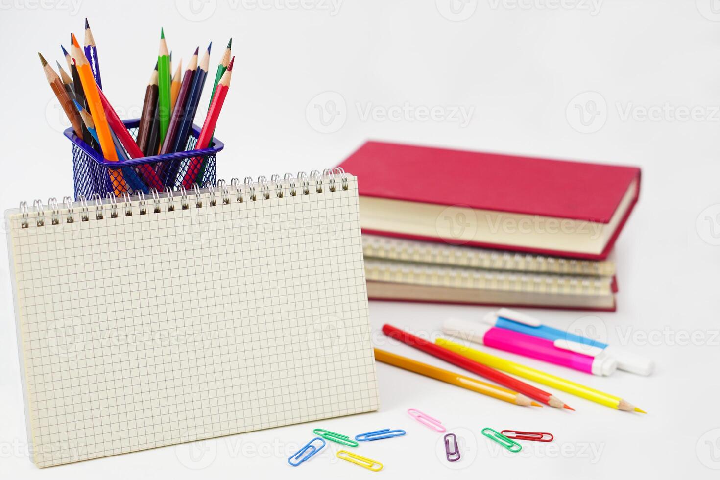 pastello o colorato matite nel scatola con lato pila di libri e scuola forniture su con sfondo. apprendimento, studia e ufficio attrezzatura concetto. foto
