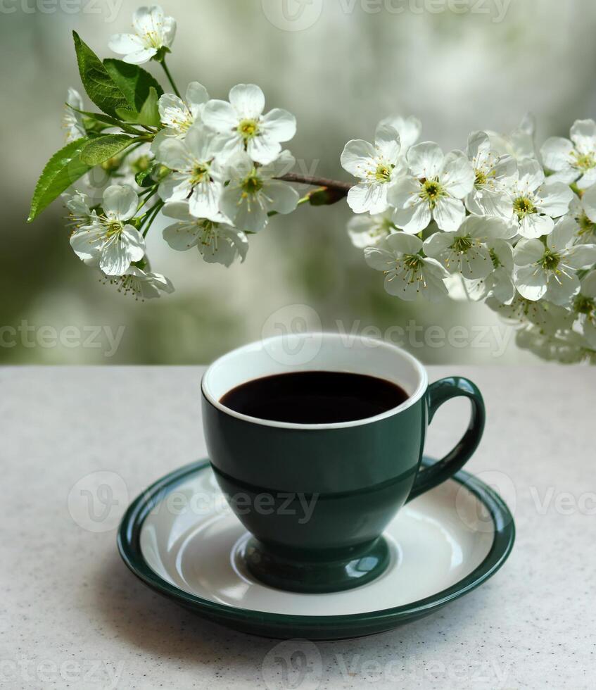 verde tazza di nero caffè espresso caffè e un' fioritura albicocca ramo nel il giardino foto