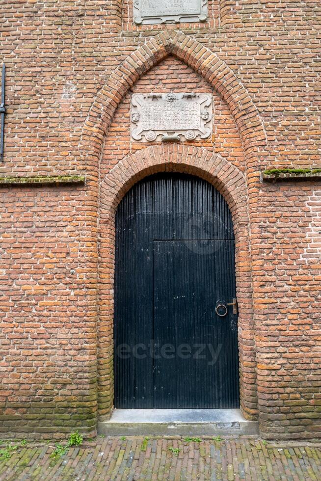 grande di legno porta nel mattone parete foto