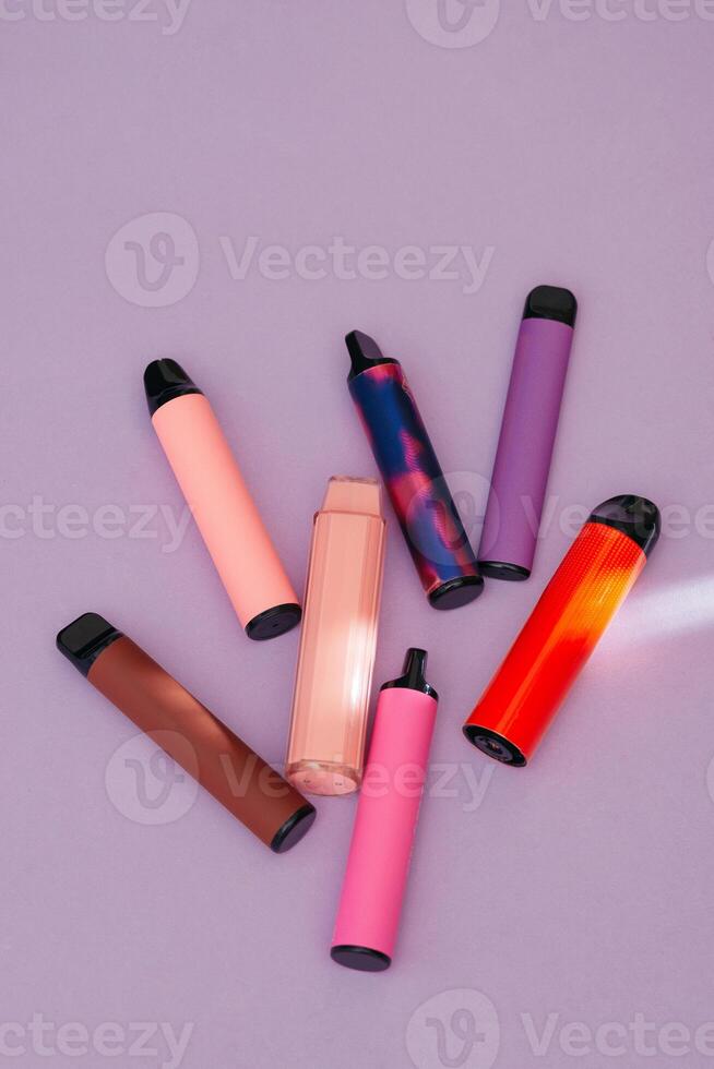 colorato monouso elettronico sigarette su un' viola sfondo. il concetto di moderno fumare, vaping e nicotina. superiore Visualizza foto