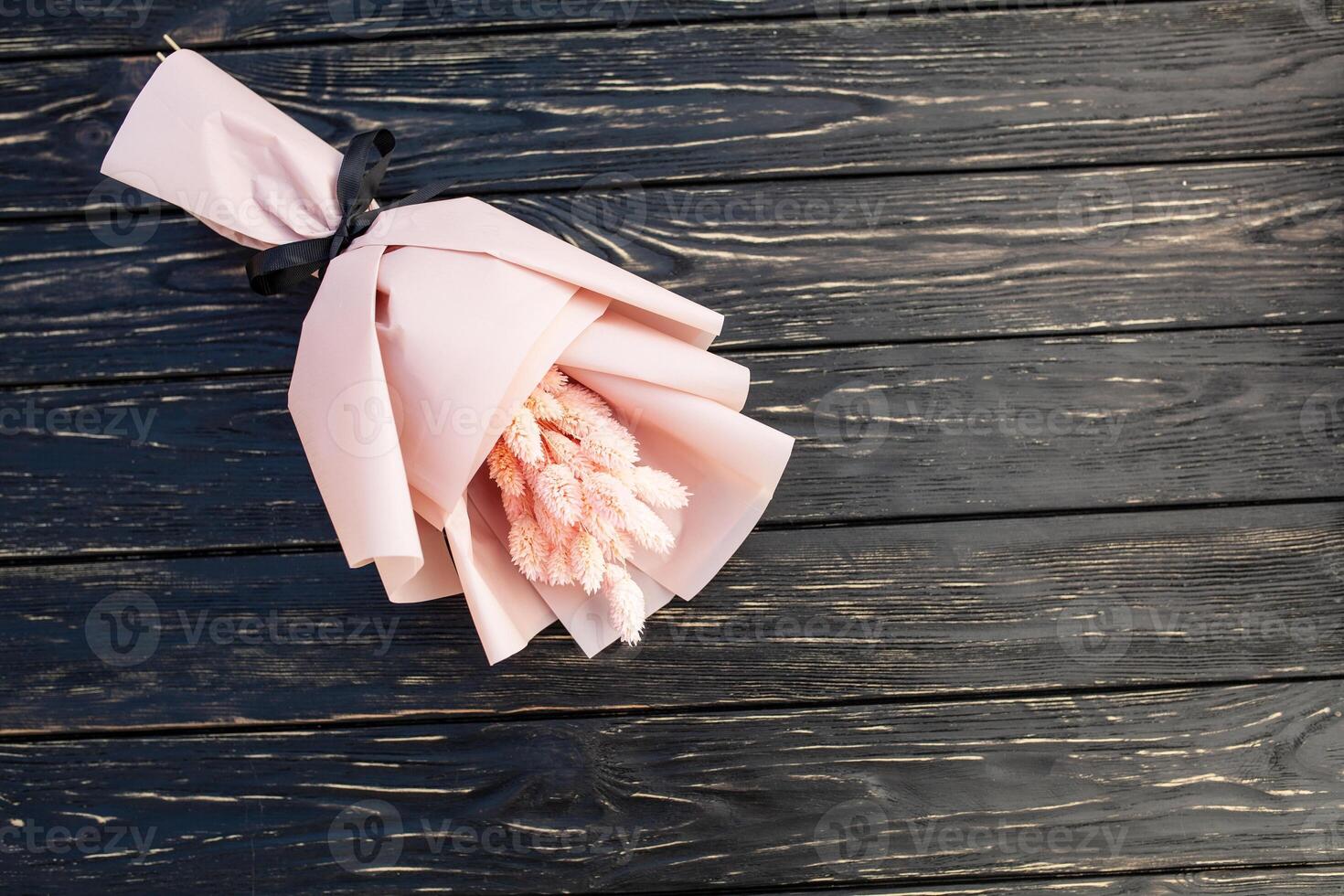 bellissimo mazzo di asciutto rosa fiori su un' di legno nero sfondo. minimalismo, spazio per testo. regalo carta foto