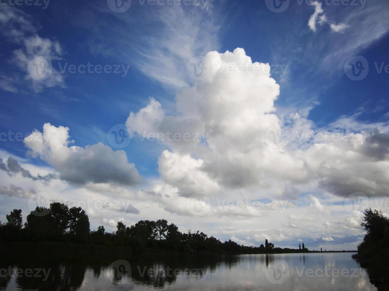 lago con blu cielo e nuvole riflettendo nel tranquillo fiume foto