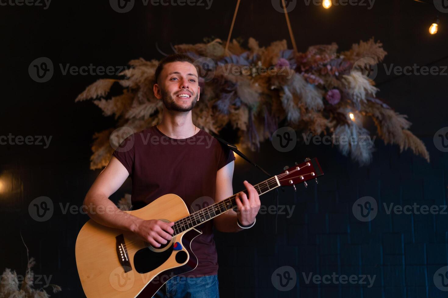 maschio musicista giocando acustico chitarra. chitarrista giochi classico chitarra su palcoscenico nel concerto foto