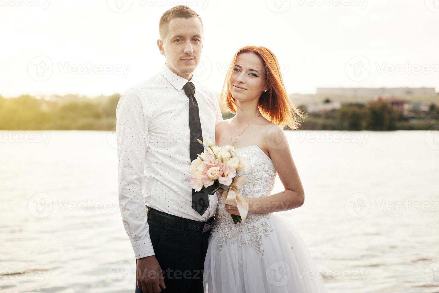 elegante dolce elegante sposo e sposa vicino fiume o lago. nozze coppia nel amore foto