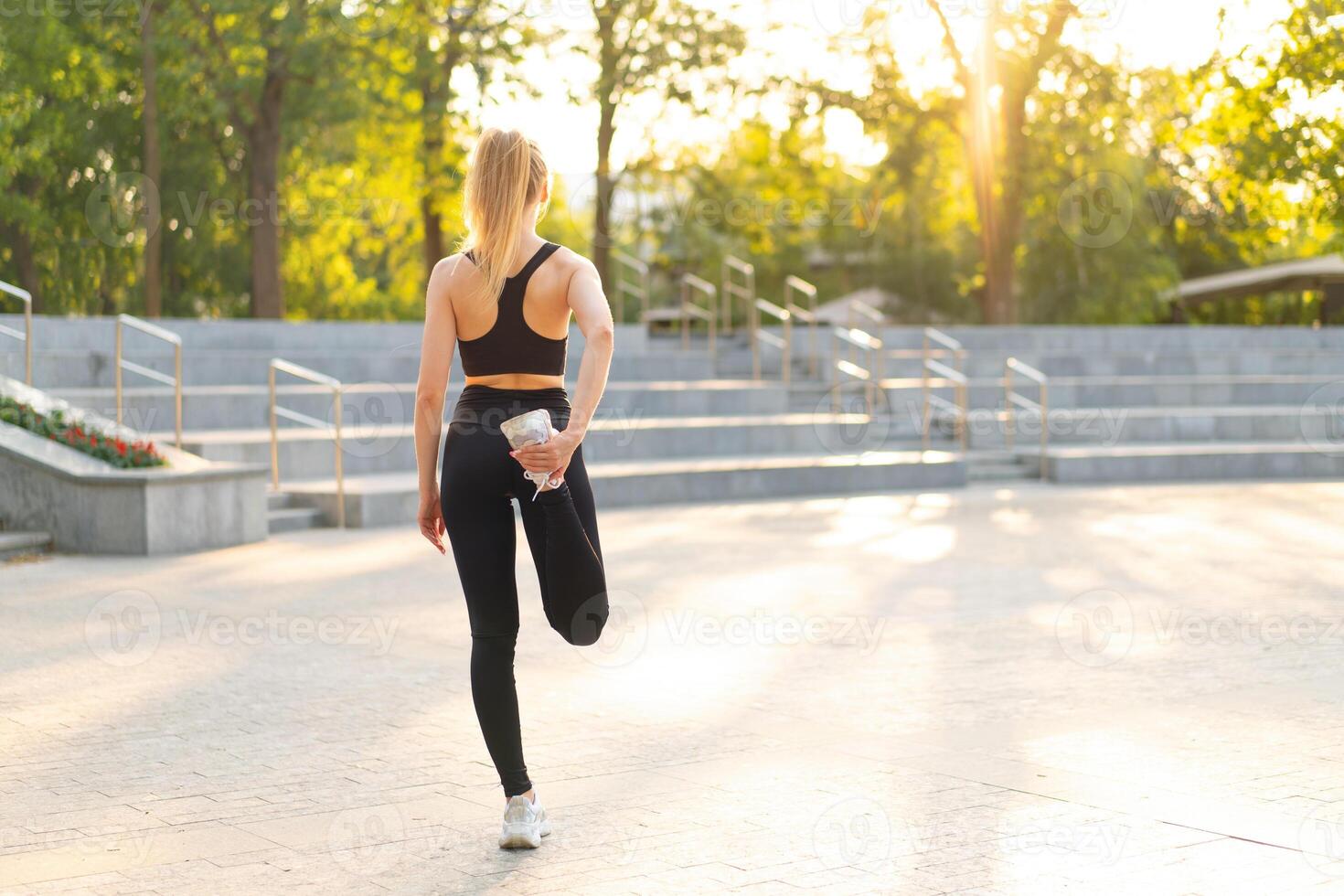 donna corridore allungamento gambe prima esercizio estate parco mattina foto