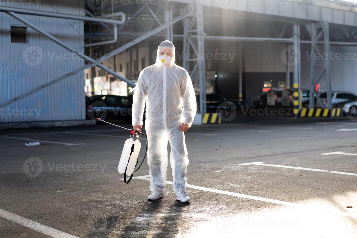 uomo vestito bianca protettivo tuta da lavoro spruzzatura superficie antibatterico disinfettante spruzzatore durante quarantena foto