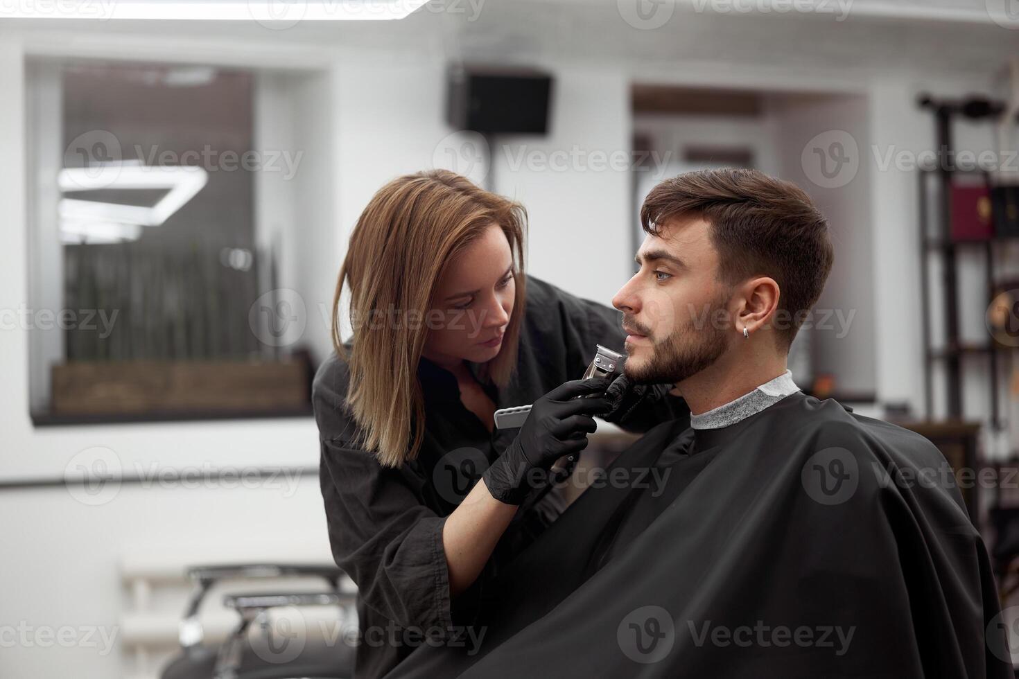 giovane bellissimo caucasico donna parrucchiere tagli barba bello uomo a moderno barbiere foto
