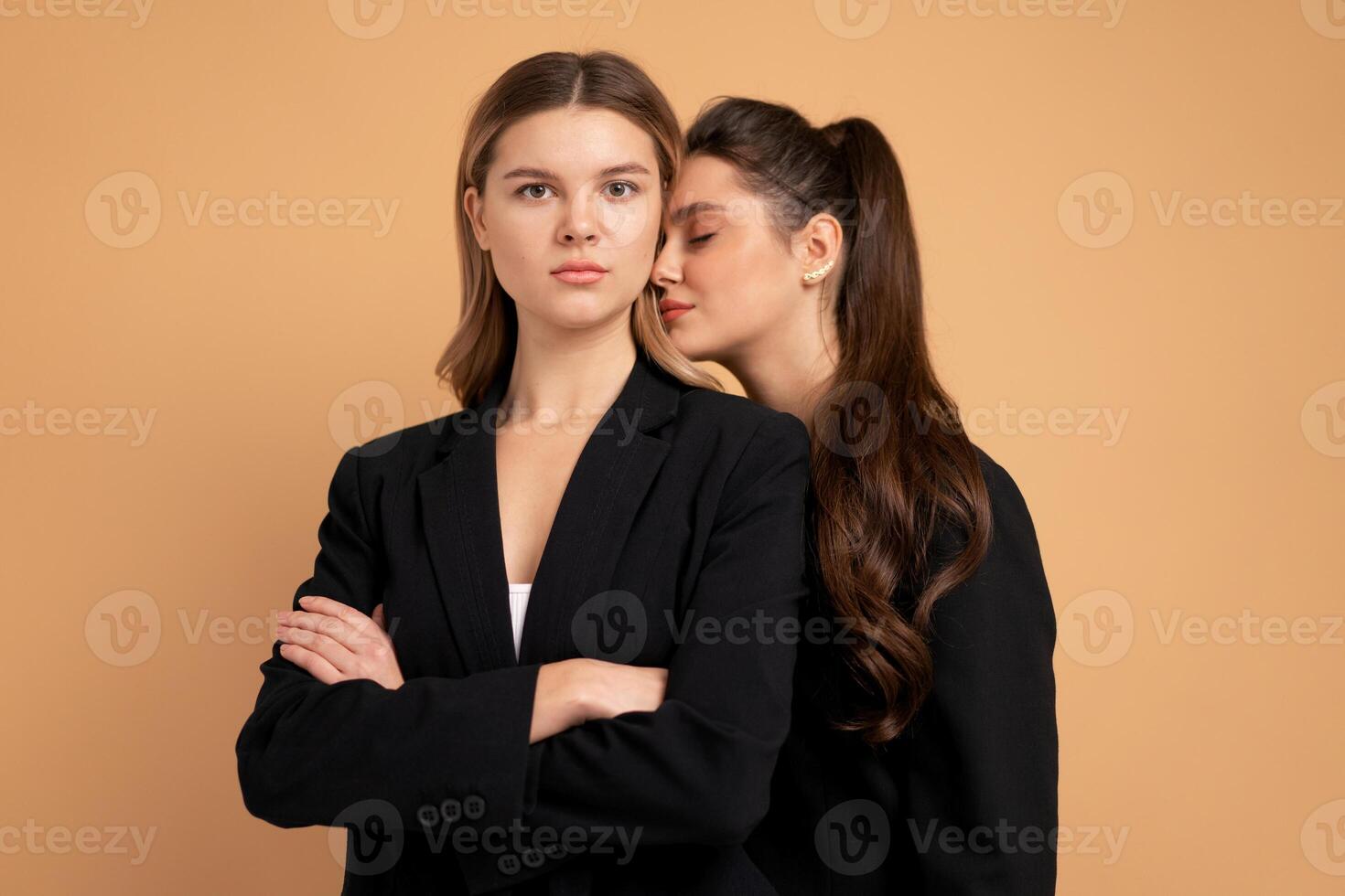 Due giovane attività commerciale donna vestito nero completo da uomo in piedi studio arancia colore sfondo foto