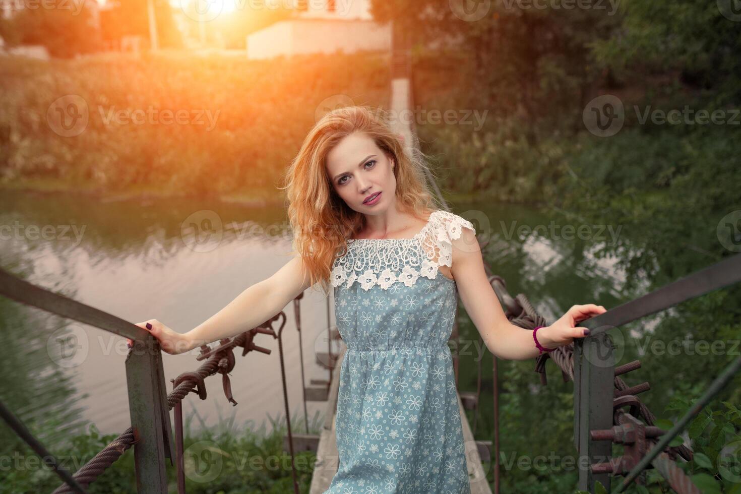 giovane bellissimo ragazza in piedi su il ponte al di sopra di il fiume. foto