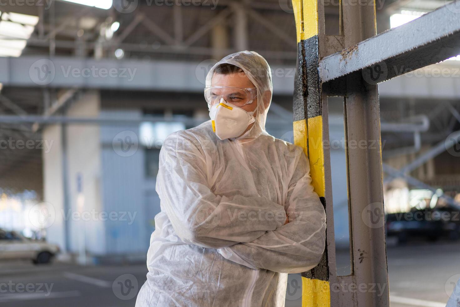 covid-19 coronavirus medico in piedi ospedale parcheggio vestito bianca protettivo tuta da lavoro Hazmat completo da uomo. foto