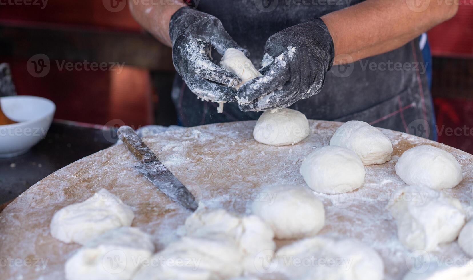 capocuoco nel nero guanti tagli crudo Impasto in pezzi rendere Pizza tortini pane. foto
