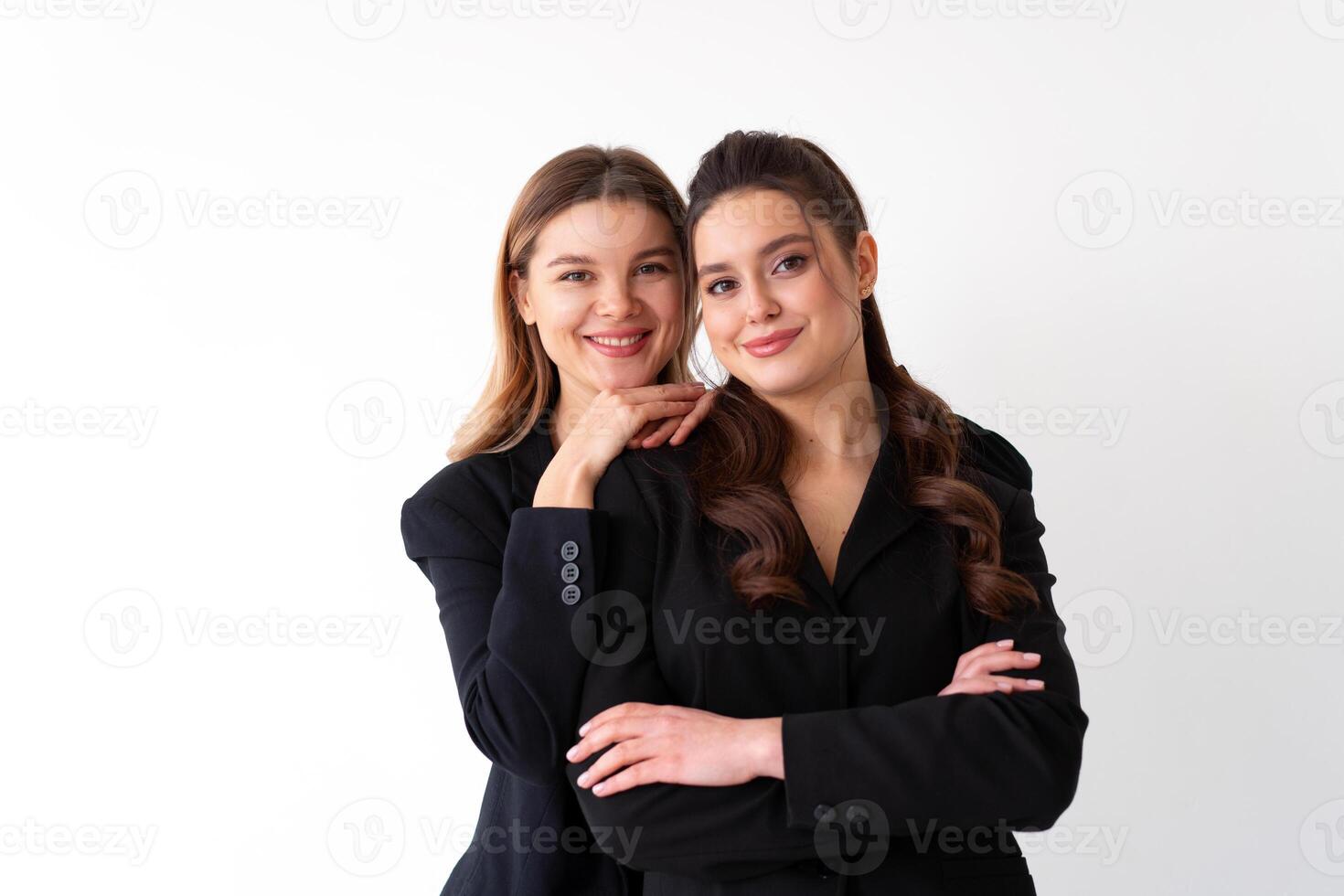 concetto di associazione nel attività commerciale. Due giovane donna d'affari vestito nero formale completo da uomo in piedi studio isolato bianca sfondo. foto