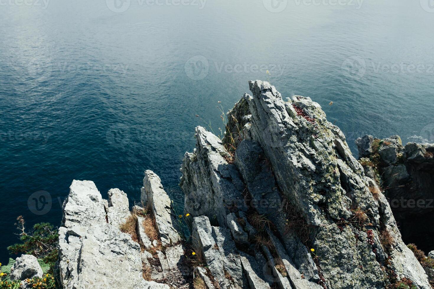 acuto scogliere appendere al di sopra di il oceano, drammatico marino sfondo foto