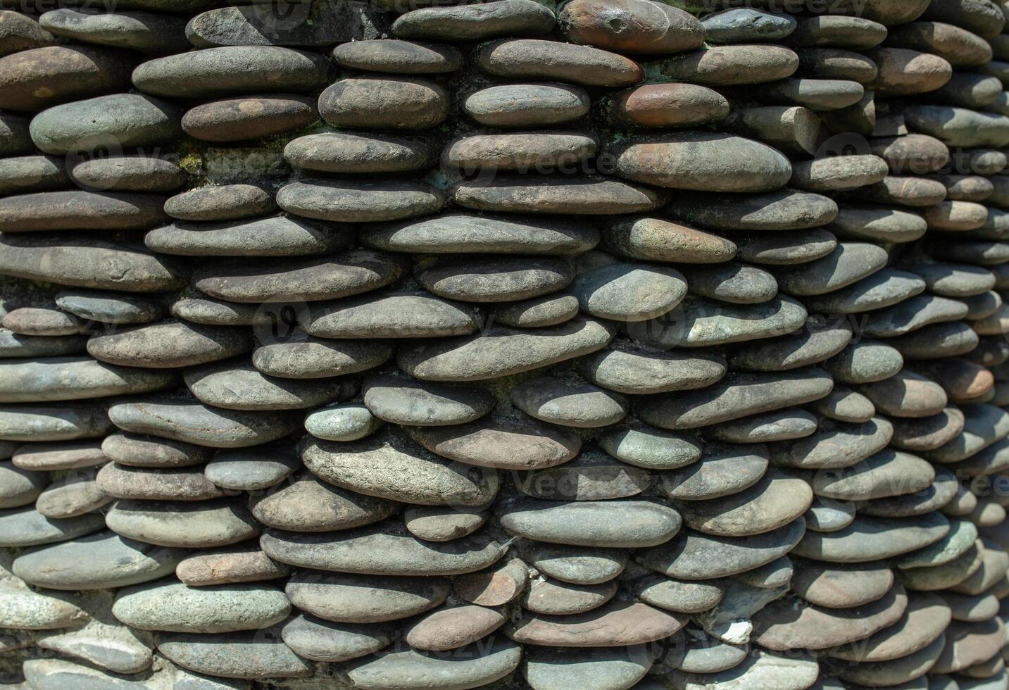 fiume ciottolo ghiaia il giro pietra parete fantasia per sfondo. grigio ciottoli sfondo per casa e casa esterno parete e pavimento decorazione. foto