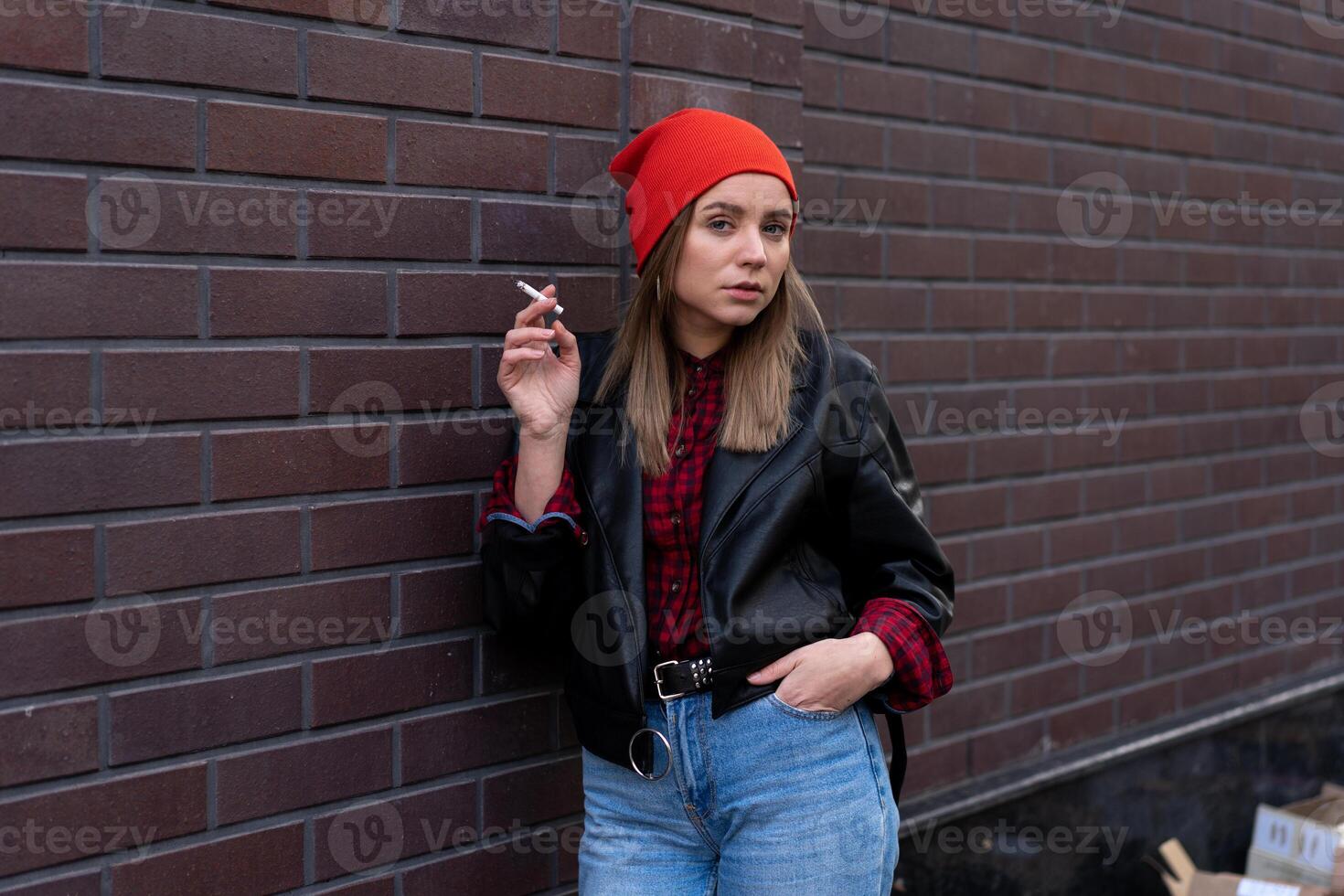 bellissimo giovane con stile vestito caucasico ragazza fuma sigaretta su il strada. foto