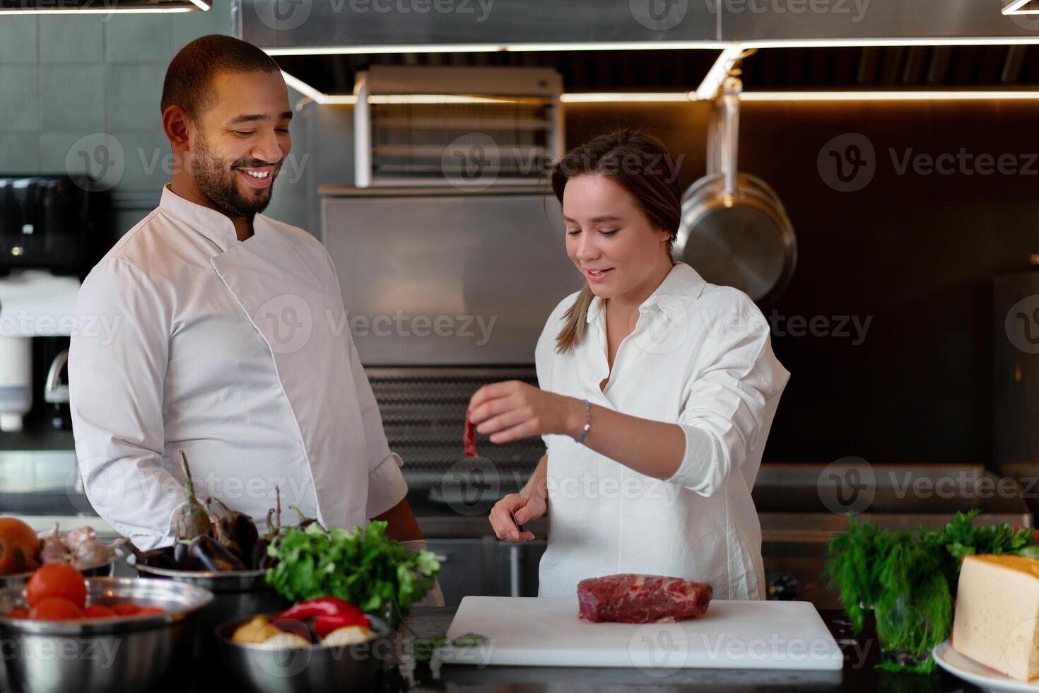 bello giovane africano capocuoco è cucinando insieme con il suo caucasico fidanzata nel il cucina utilizzando rosso vino come un ingrediente. foto