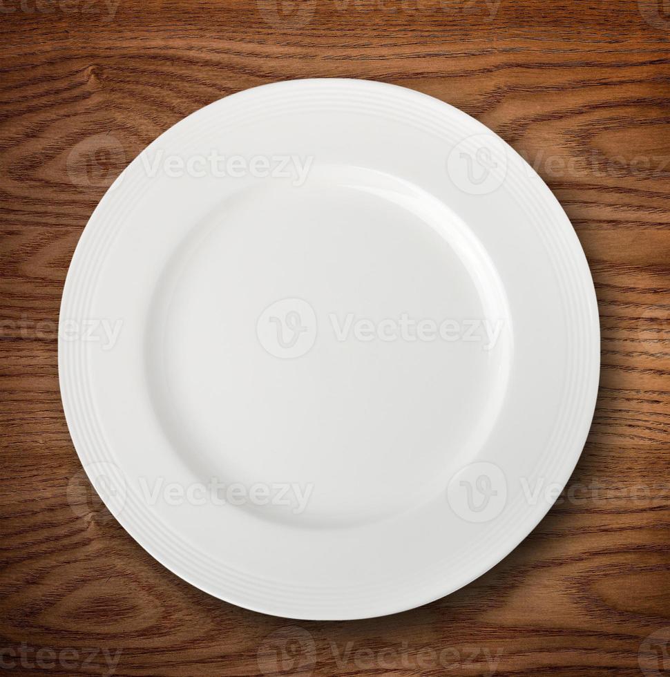 piatto bianco vuoto sul tavolo di legno foto
