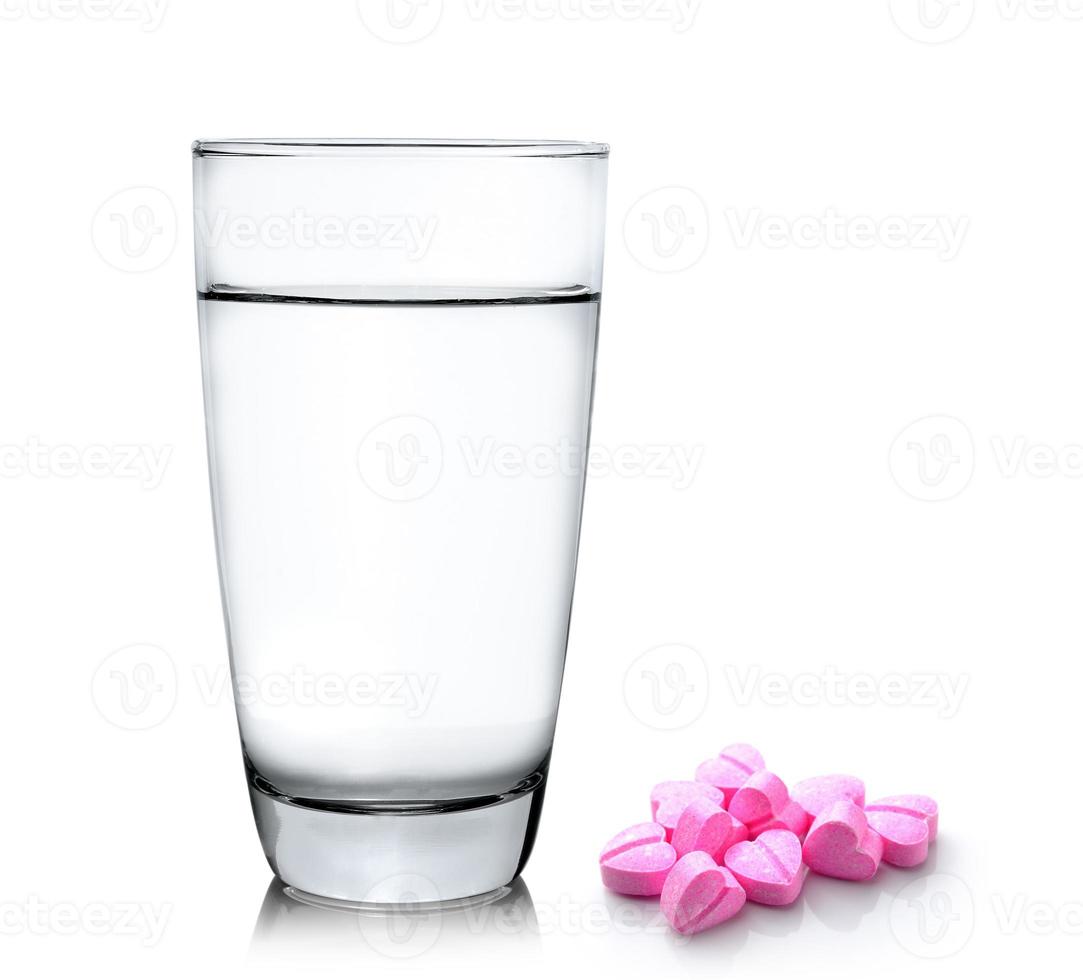 bicchiere d'acqua e pillole isolati su fondo bianco foto