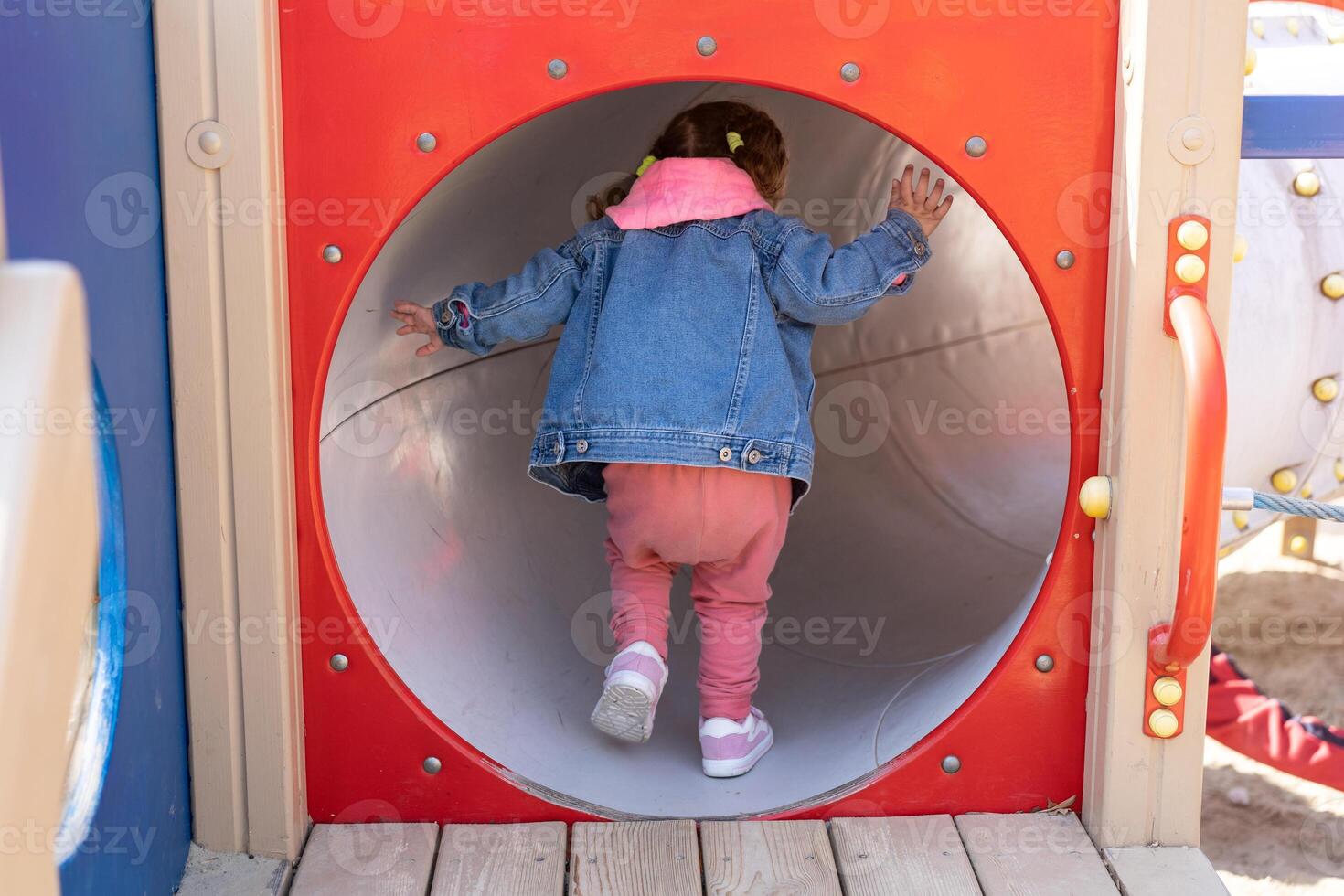 carino poco caucasico ragazza su il terreno di gioco, contento bambino con piacere la spesa tempo all'aperto, contento spensierato infanzia foto