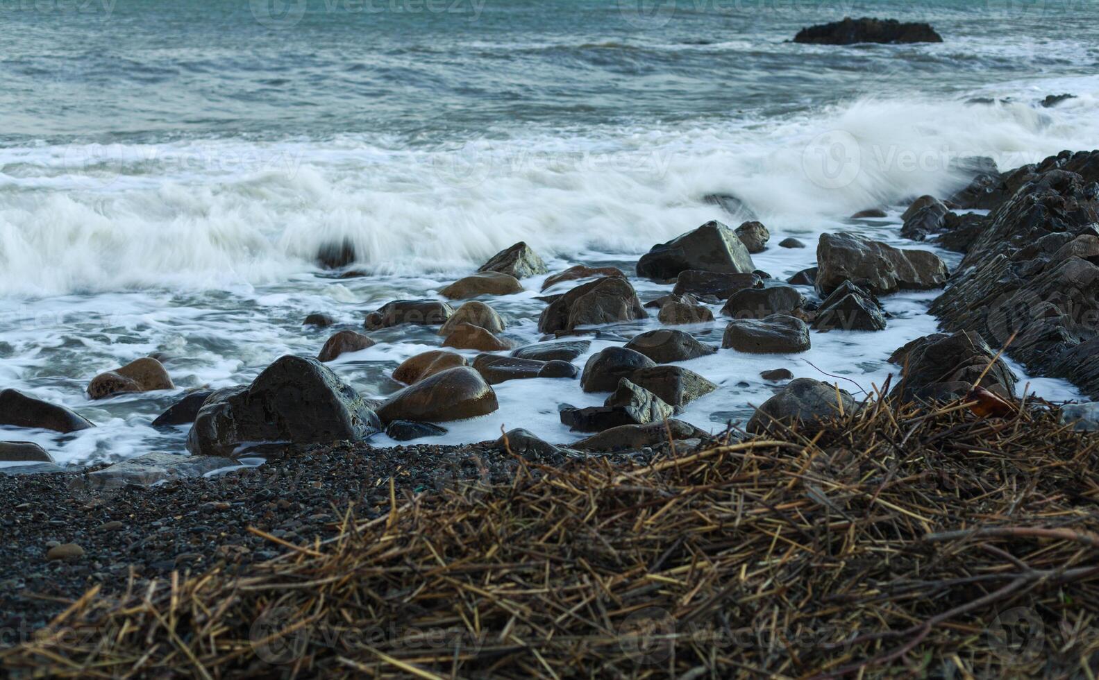 tagliente pietra nel il mare o oceano schiuma onda foto