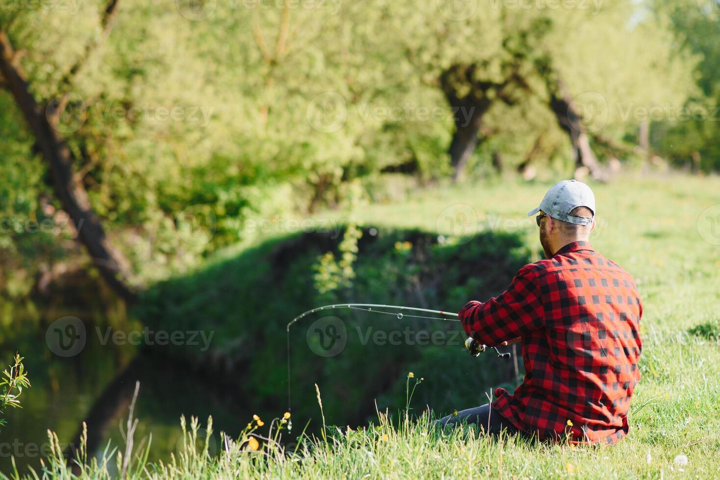 giovane pescatore Pesci vicino il fiume. il concetto di all'aperto attività e pesca foto