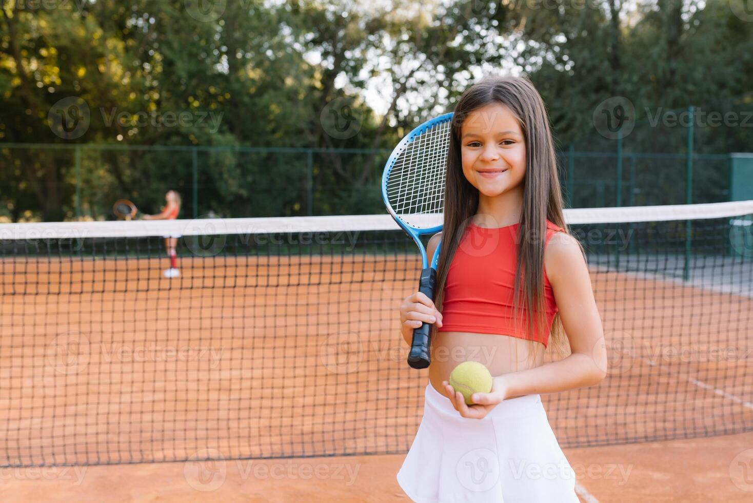 bambino giocando tennis su all'aperto Tribunale. poco ragazza con tennis racchetta e palla nel sport club. attivo esercizio per bambini. estate attività per bambini. formazione per giovane ragazzo. bambino apprendimento per giocare foto