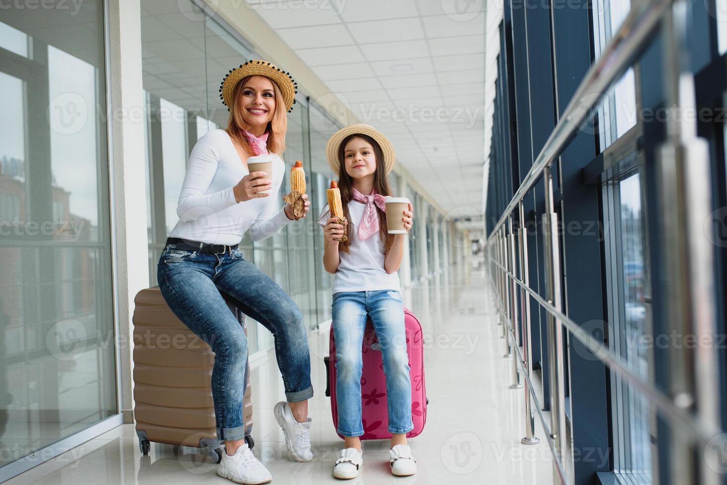 mamma con sua figlia a aeroporto terminale con valigie mangiare veloce cibo foto