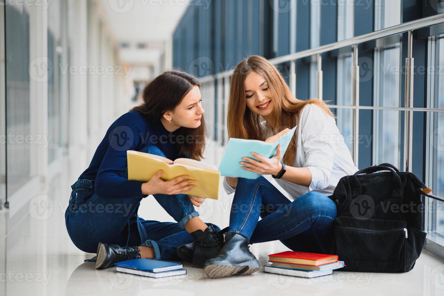 femmina studenti seduta su il pavimento e lettura Appunti prima esame foto