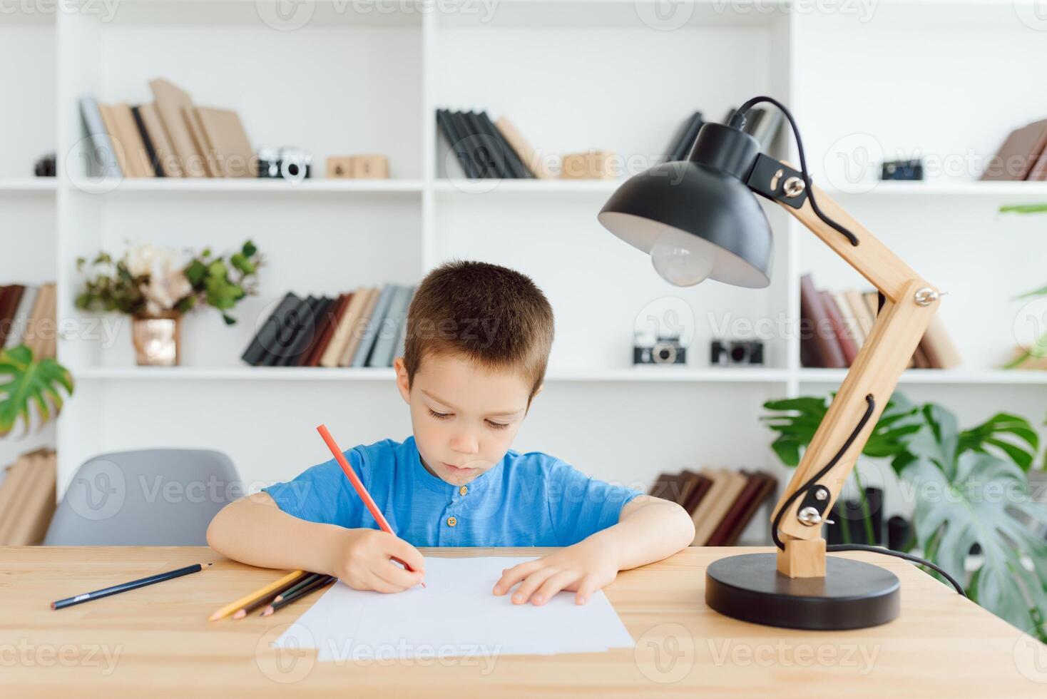 formazione scolastica, infanzia, le persone, compiti a casa e scuola concetto - sorridente alunno ragazzo con libro scrittura per taccuino a casa foto