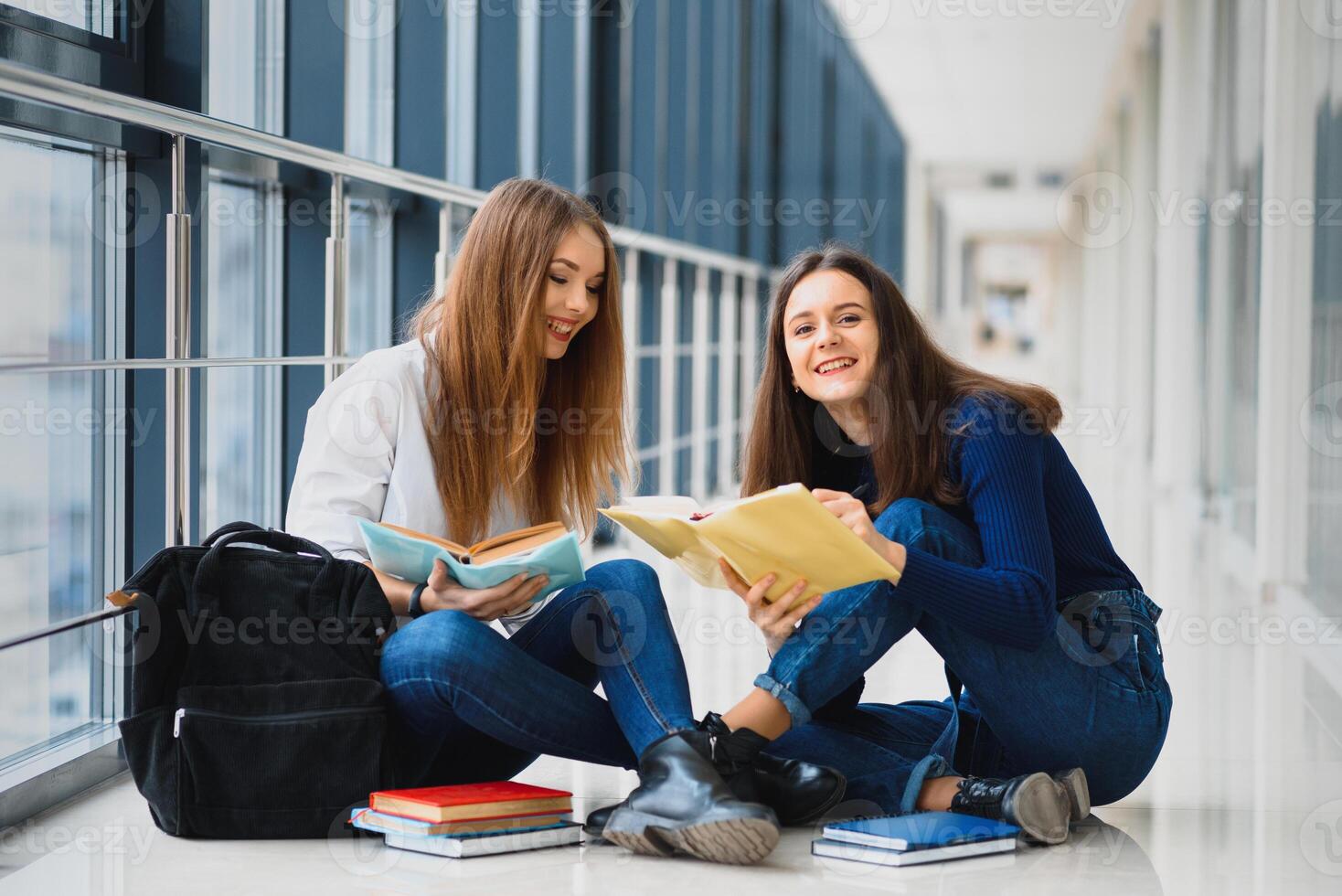 femmina studenti seduta su il pavimento e lettura Appunti prima esame foto