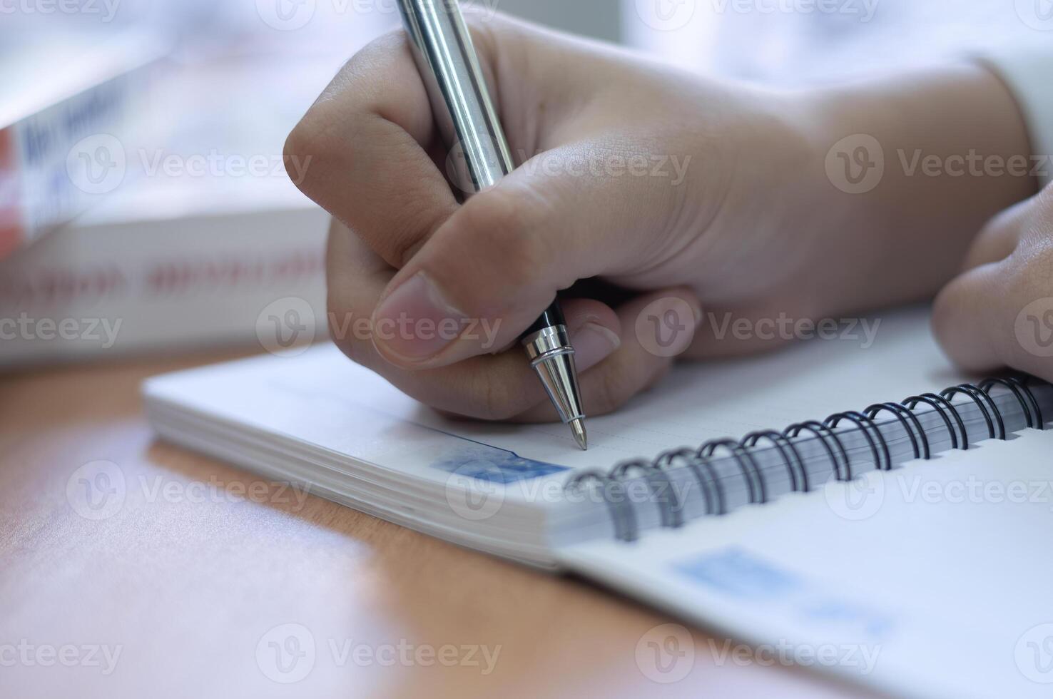 mani scrittura su un' vuoto libro nel ufficio scrivania foto