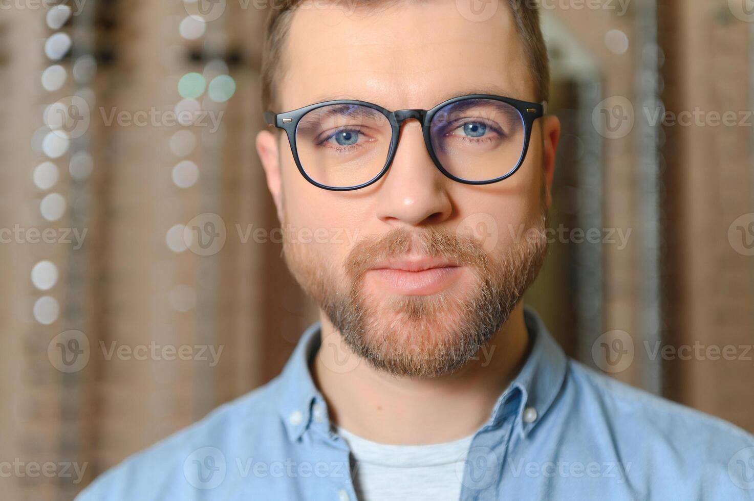 soddisfatto cliente. al di sopra di il spalla Visualizza di contento giovane maschio cliente indossare nuovo occhiali. foto