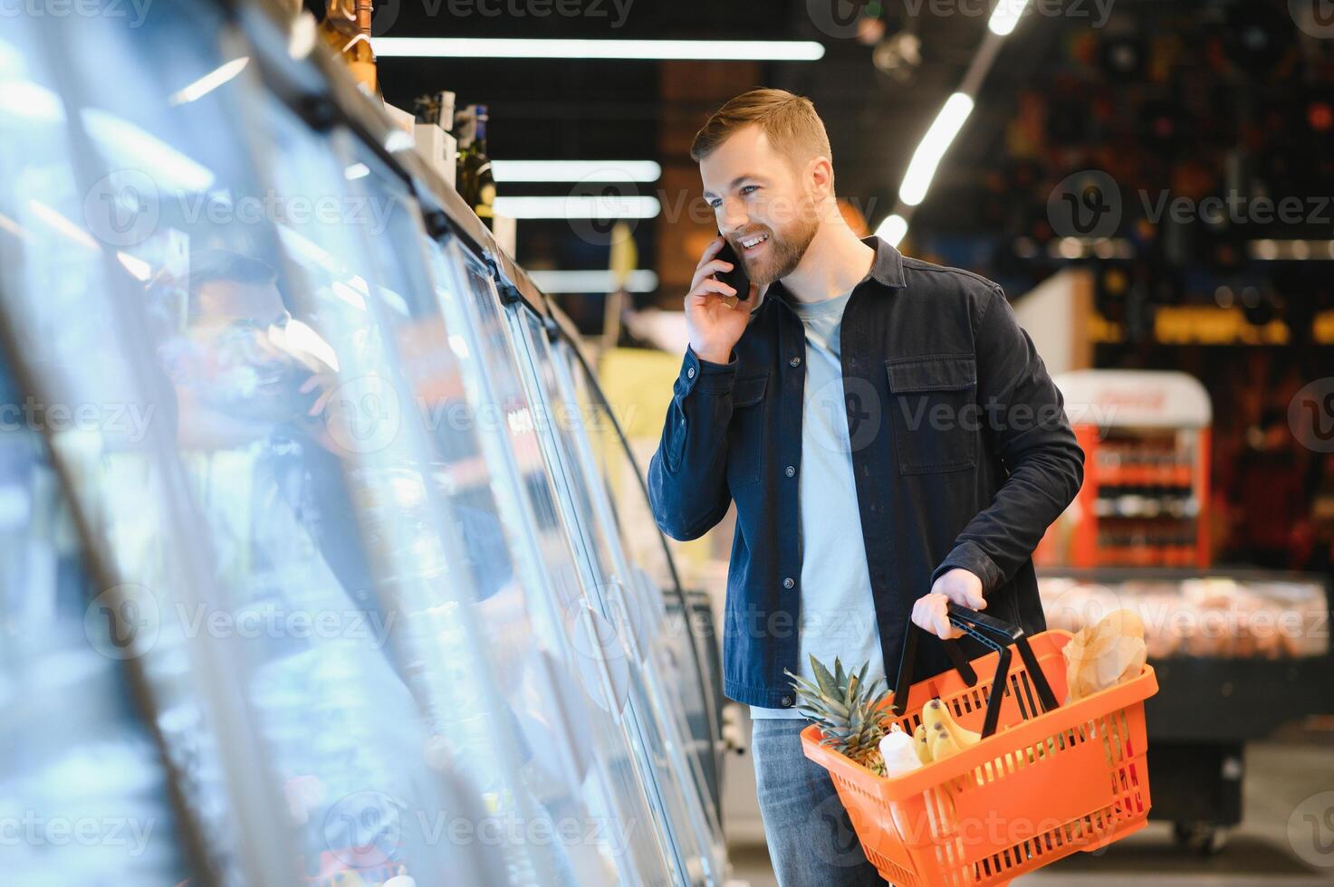 giovane uomo acquisto drogheria a il supermercato. altro i clienti nel sfondo. consumismo concetto. foto