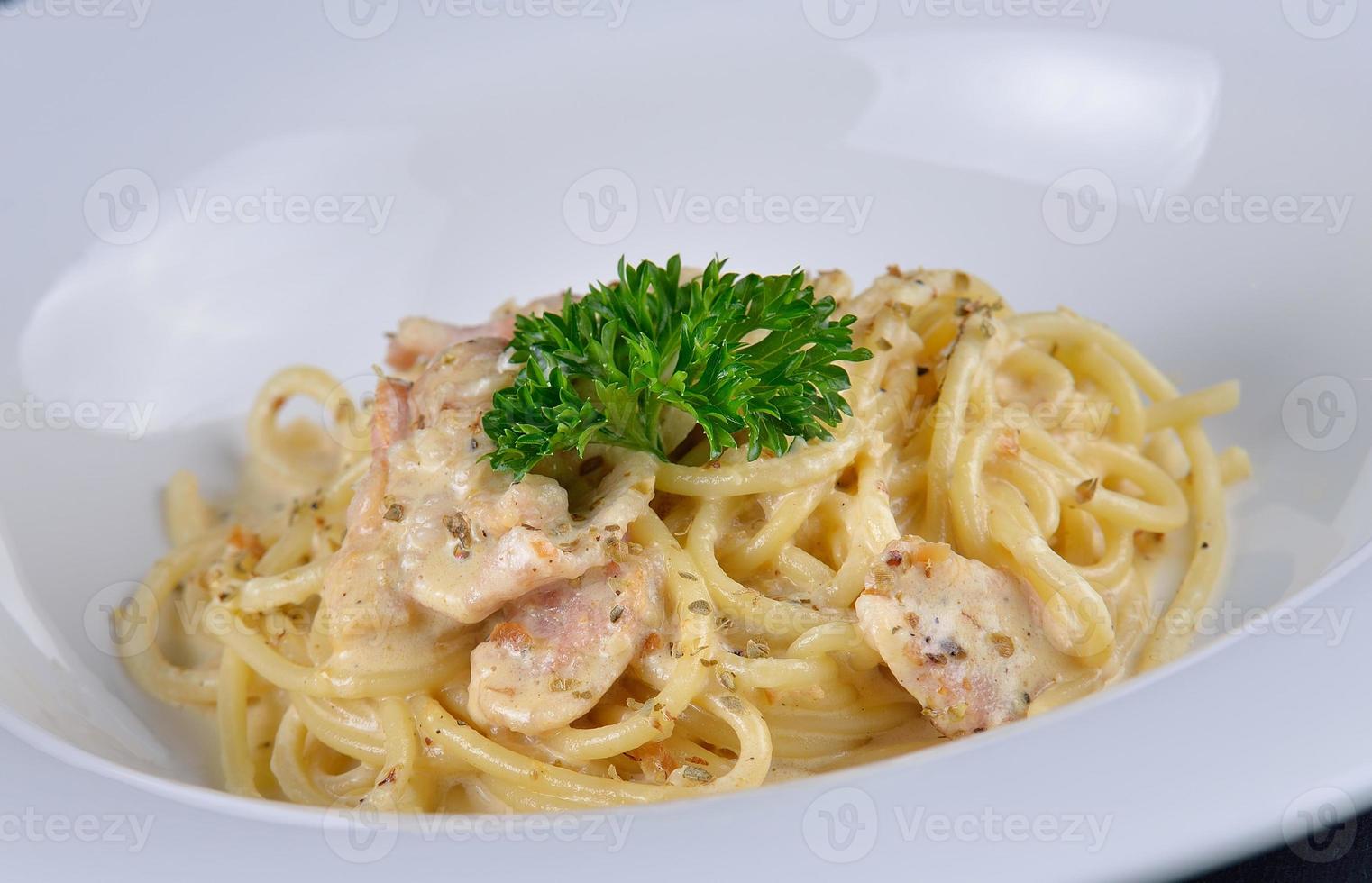 spaghetti alla carbonara su piatto bianco foto