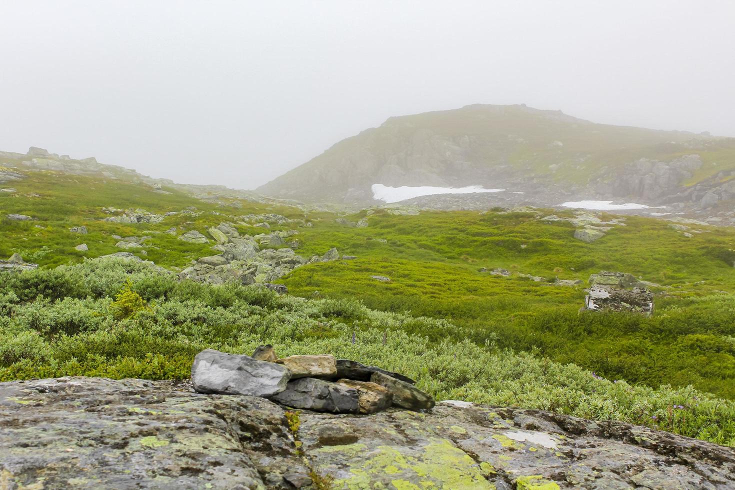 nebbia, nuvole, rocce e scogliere sulla montagna veslehodn veslehorn, norvegia. foto