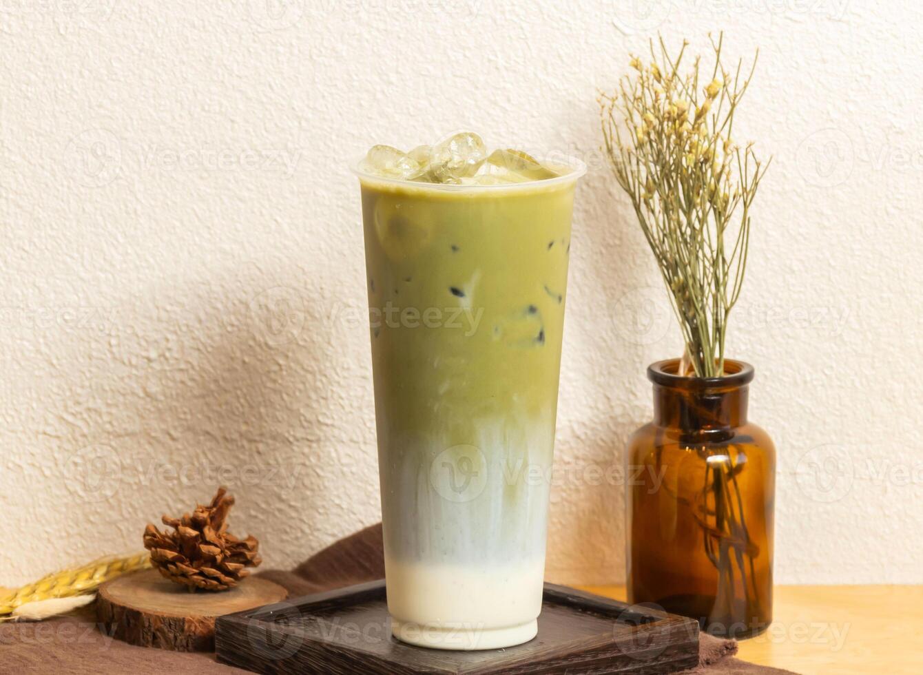 ghiacciato kyoto matcha latte macchiato tè servito nel monouso bicchiere isolato su di legno tavola lato Visualizza di taiwanese ghiaccio bevanda foto